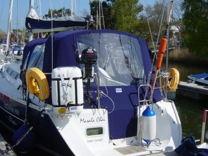 Cockpit enclosure for Beneteau Oceanis 323 with Tecsew Sprayhood Recover Type 2, featuring Sunbrella fabric and clear windows.