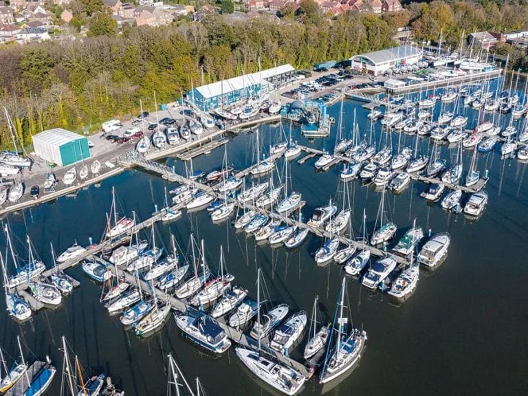 Scenic view of Deacons Marina with sailboats and motorboats equipped with high-quality custom covers and marine canvas under a clear, sunny sky
