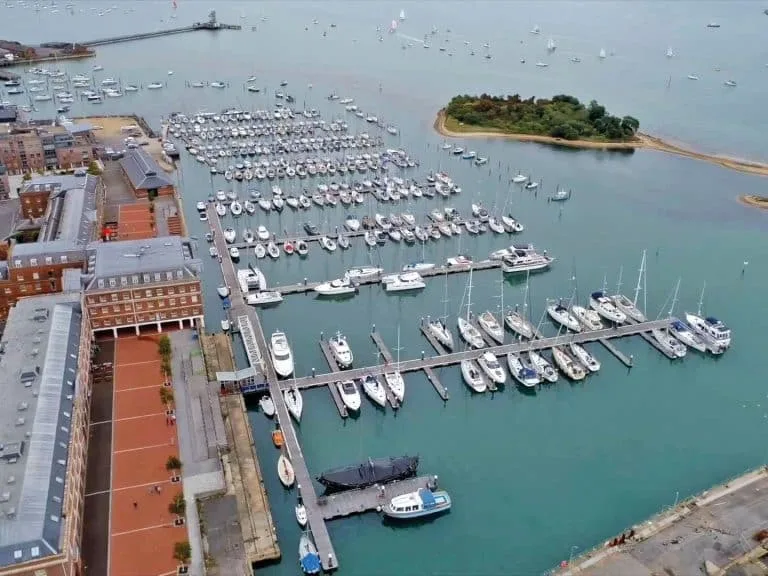 View of Royal Clarence Marina with historic buildings and yachts, highlighting its blend of maritime heritage and modern facilities.