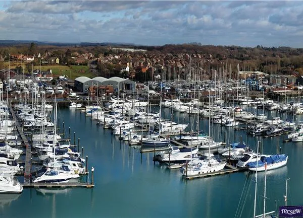 Scenic view of Swanwick Marina with sailboats and motorboats equipped with custom covers and marine canvas from Tecsew under a clear, sunny sky.
