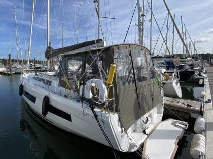 Dufour 41 with a fully installed bimini conversion-enclosure offering complete cockpit protection.