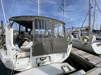 Dufour 41 with a fully installed bimini conversion-enclosure offering complete cockpit protection.