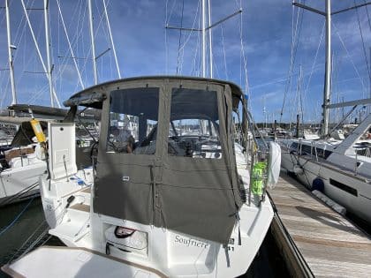 Dufour 41 with a fully installed bimini conversion-enclosure offering complete cockpit protection.
