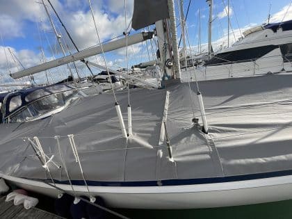 Malo 41 deck covers in Sunbrella Plus fabric, protecting teak decks and zipping to the cockpit enclosure