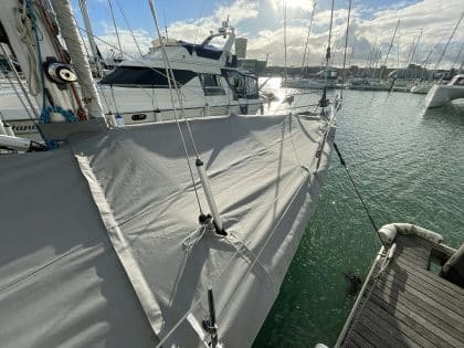 Malo 41 deck covers in Sunbrella Plus fabric, protecting teak decks and zipping to the cockpit enclosure