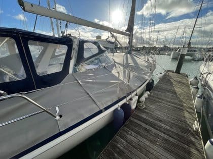 Malo 41 deck covers in Sunbrella Plus fabric, protecting teak decks and zipping to the cockpit enclosure