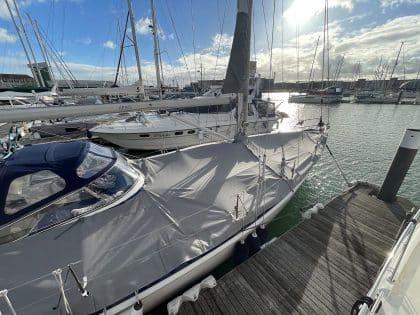 Malo 41 deck covers in Sunbrella Plus fabric, protecting teak decks and zipping to the cockpit enclosure