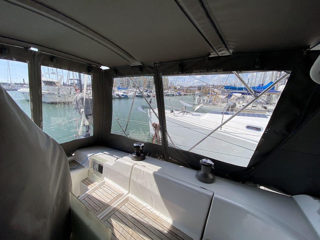 Hanse 400e bimini enclosure with Sunbrella fabric and clear windows, providing a fully enclosed cockpit.