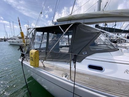 Hanse 400e bimini enclosure with Sunbrella fabric and clear windows, providing a fully enclosed cockpit.
