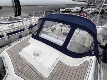 Custom sprayhood for Oyster 435 with stainless steel frame, Sunbrella fabric, and clear windows for durability and visibility.