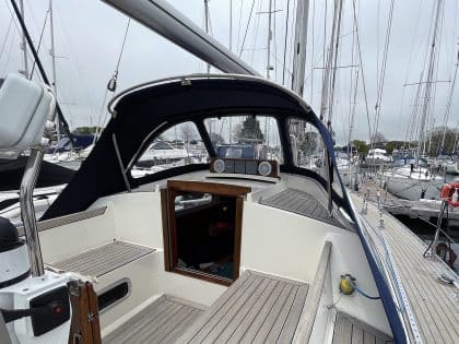 Custom sprayhood for Oyster 435 with stainless steel frame, Sunbrella fabric, and clear windows for durability and visibility.